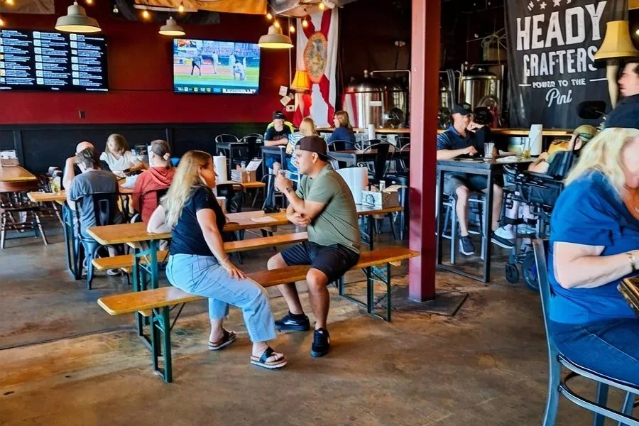 Engine 15 Brewing Company taproom interior with patrons at communal tables in Jacksonville Beach